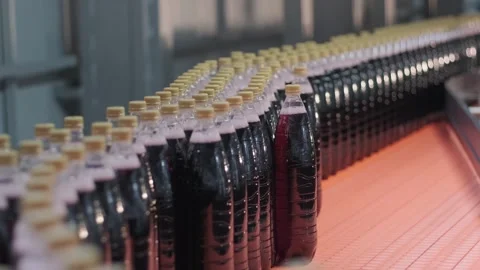 Curved conveyor section moving rows of plastic bottles in drinks factory.	 Stock Footage 311575592