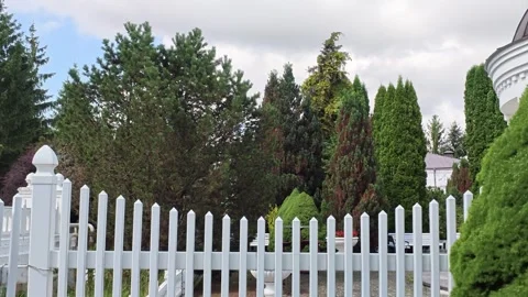Curved garden walkway bordered by evergreen trees, trimmed shrubs, mulch beds Video stock 343516793