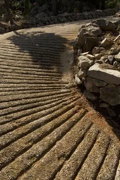 Curved grooved stone path with rustic rock wall Stock Photos