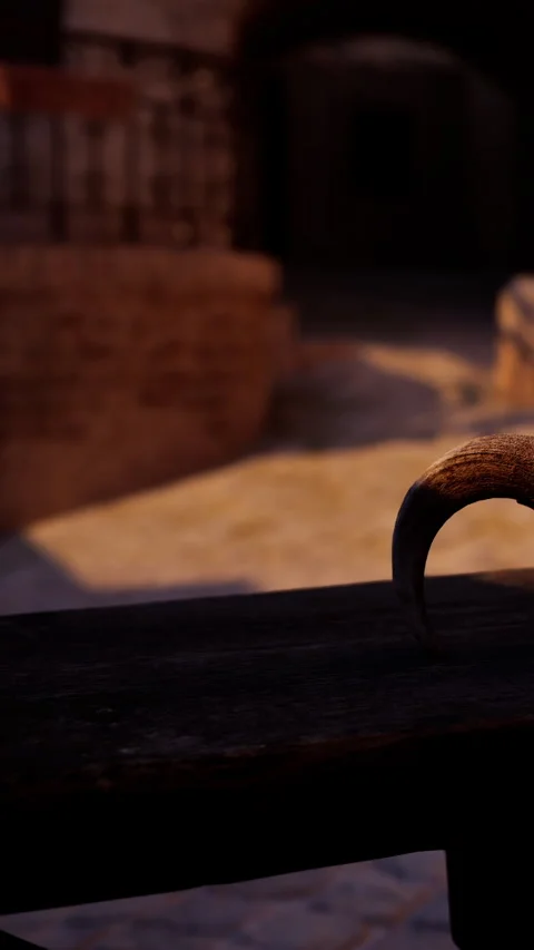 Curved handle on a wooden surface in a shadowed setting during dusk Vidéo 342337774