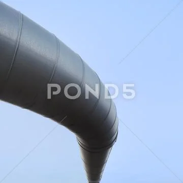 Curved industrial pipe line, sky background. geothermal power plant. Stock Photos