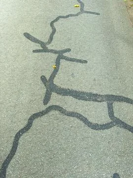 Curved lines and patterns stretch across the asphalt, catching the warm sunli Stock Photos
