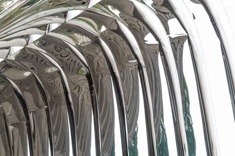 Curved metallic structure reflecting abstract shapes and patterns Illustrazione stock