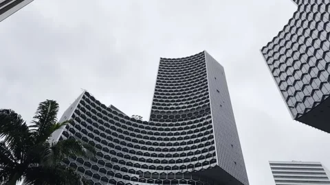 Curved modern skyscraper with hexagonal facade pattern and windows Stock Footage 298077202