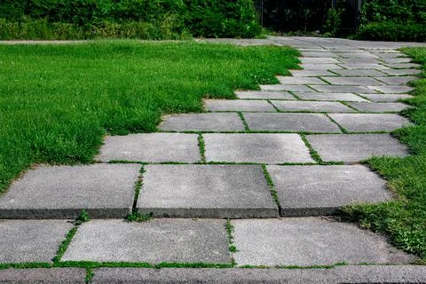 Curved park way made of square stone tiles. Stock Photos