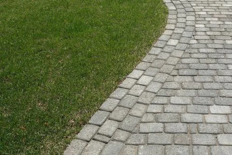 Curved path in the shape of a wave on the grass in the Park. Paved with tiles Stock Photos
