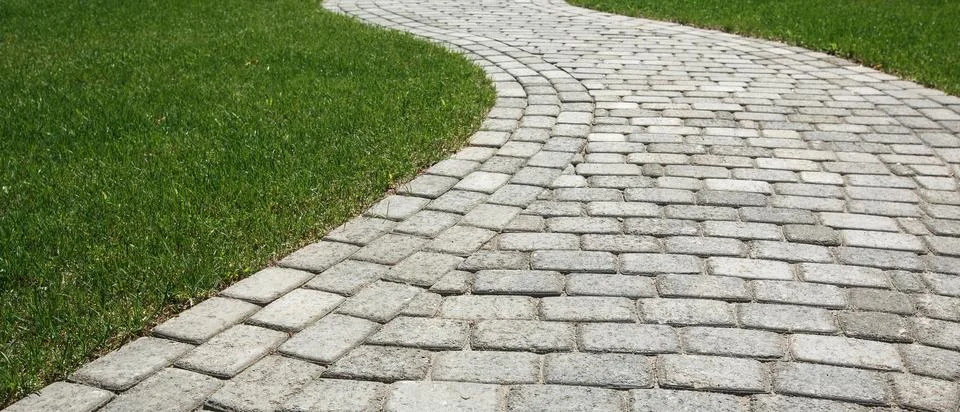 Curved path in the shape of a wave on the grass in the Park. Paved with tiles Stock Photos