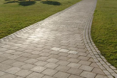 Curved path in the shape of a wave on the grass in the Park. Paved with tiles Stock-Fotos