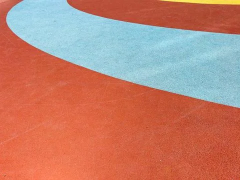 Curved patterns in red, blue, and yellow create a vibrant surface at a playgr Stock Photos