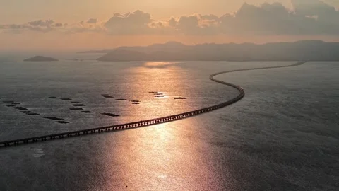 Curved Penang Second Bridge stretching across calm sea water during sunset Видео 336882770
