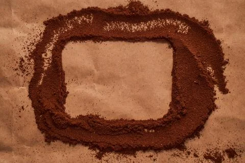 A curved rectangle of ground coffee on a brown background. Place to insert a Stock Photos