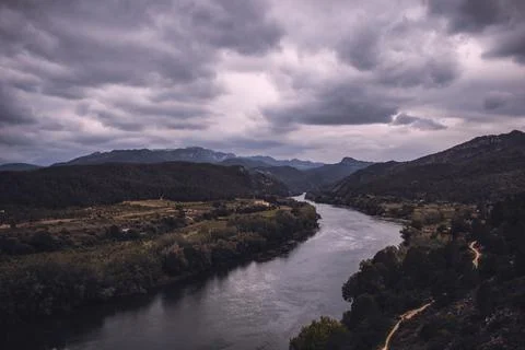 Curved river under a cloudy sky Stock Photos