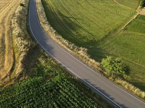 Curved road between crop fields in the countryside from above Stock Photos