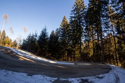 Curved road through the forest going up on to the mountain. Stock Photos