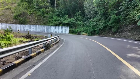 Curved road winds through green hills Видео 345153659