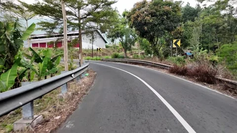 Curved road winds through lush green hills Stock Footage 345151905