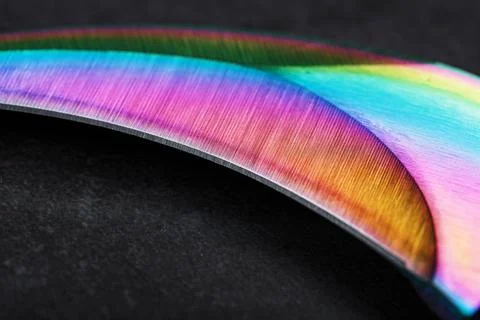 The curved sharp blade of the Kerambit Dagger is a gradient rainbow color on  Stock Photos