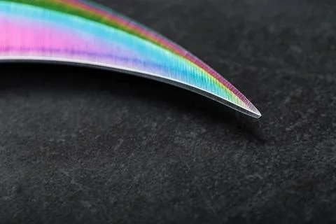 The curved sharp blade of the Kerambit Dagger is a gradient rainbow color on  Stock Photos