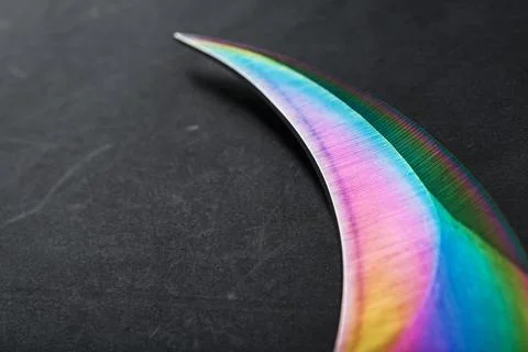 The curved sharp blade of the Kerambit Dagger is a gradient rainbow color on  Stock Photos