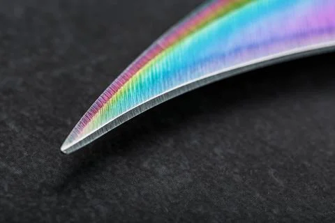 The curved sharp blade of the Kerambit Dagger is a gradient rainbow color on  Stock Photos