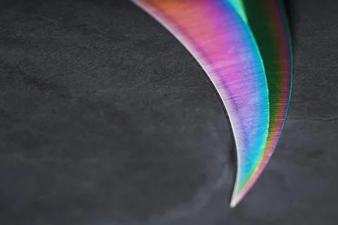 The curved sharp blade of the Kerambit Dagger is a gradient rainbow color on a Stock Photos