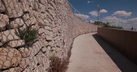 Curved stone retaining wall along pedestrian walkway in Sibenik Croatia Stock-Footage 336141162