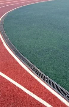 Curved track surface featuring vibrant red and green colors, showcasing athletic Stock-Fotos