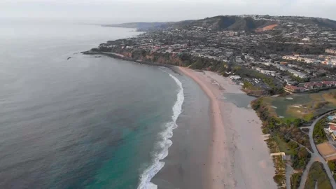 Curving Beach, Surf and Coastal Neighborhood, Aerial Pullback, 4K Stock Footage 147910901