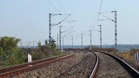 Curving electrified railway tracks through rural landscape Stock Footage 330705947