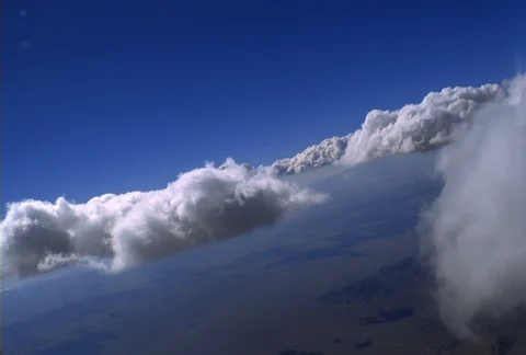 A curving flight passes between scattered white puffy clouds that float in Video stock 86832368