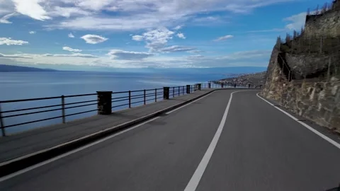 A curving road along the cliffs of Lavaux, Switzerland, with Lake Geneva Stock-Footage 330616287