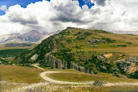 Curving Trail Through Rugged Green Mountain Landscape Foto stock