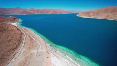 Curving Yamdrok Lake shore and road beside blue water Video stock 345885853