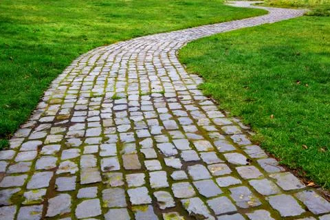 Curvy brick path in grass Stock Photos