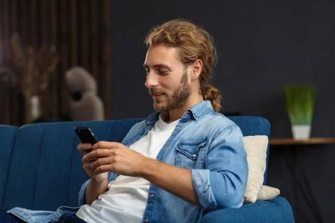 Curvy guy using smartphone and smiling. Happy man using mobile phone apps Stock Photos