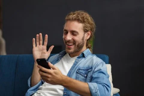 Curvy guy using smartphone and smiling. Happy man using mobile phone apps Stock Photos