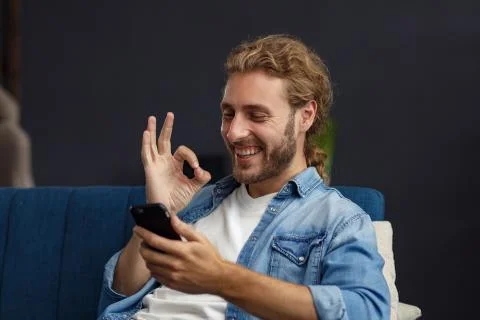 Curvy guy using smartphone and smiling. Happy man using mobile phone apps Stock Photos