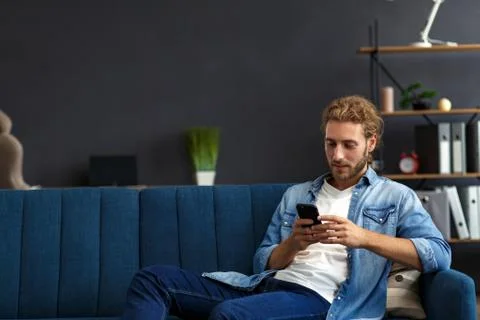 Curvy guy using smartphone and smiling. Happy man using mobile phone apps 스톡 사진
