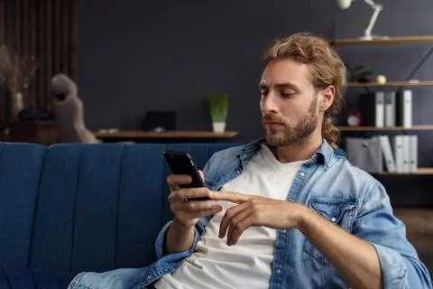 Curvy guy using smartphone and smiling. Happy man using mobile phone apps Stock Photos