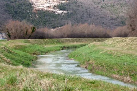A curvy river surrounded by a forest in winter time Foto stock