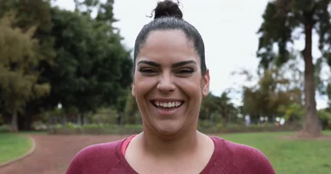 Curvy woman smiling in camera while doing jogging routine outdoor Stock Footage 153462094