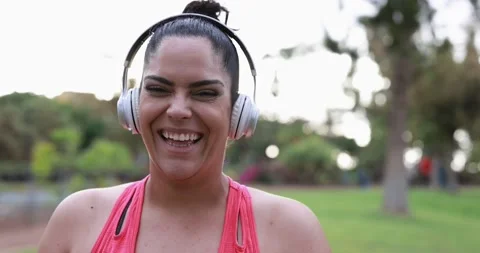 Curvy woman smiling in camera while doing jogging routine outdoor Видео 153462252