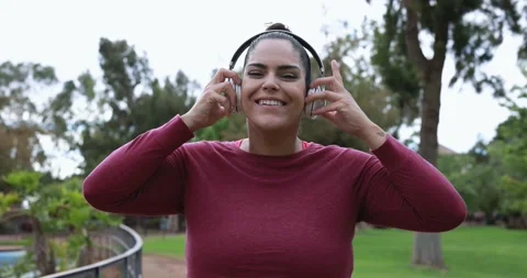 Curvy woman smiling in camera while doing jogging routine at park Stock Footage 153462401