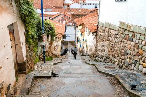 Cusco, Peru - February 9, 2018: A man goes down the stairs of a narrow alley Stock Photos