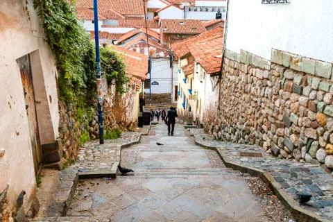 Cusco, Peru - February 9, 2018: A man goes down the stairs of a narrow alley  Stock Photos