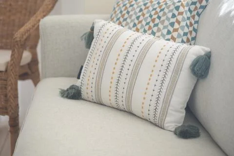 Cushion on a light sofa with pattern and tassels Stock Photos