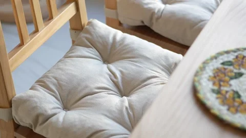 Cushioned chairs and a round mat on a wooden table Stock Footage 331274658