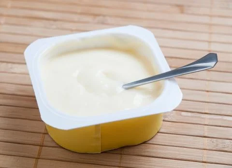 Custard and spoon inside Stock Photos