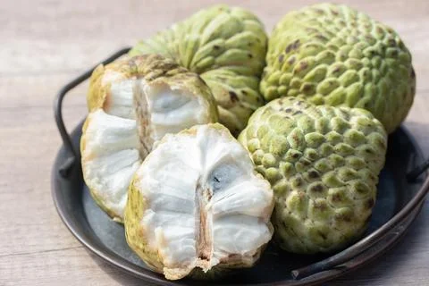 Custard apple and halved fruit on wooden background 写真素材
