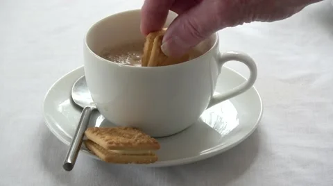Custard cream biscuits being dunked into a cup of tea Stock Footage 67277508